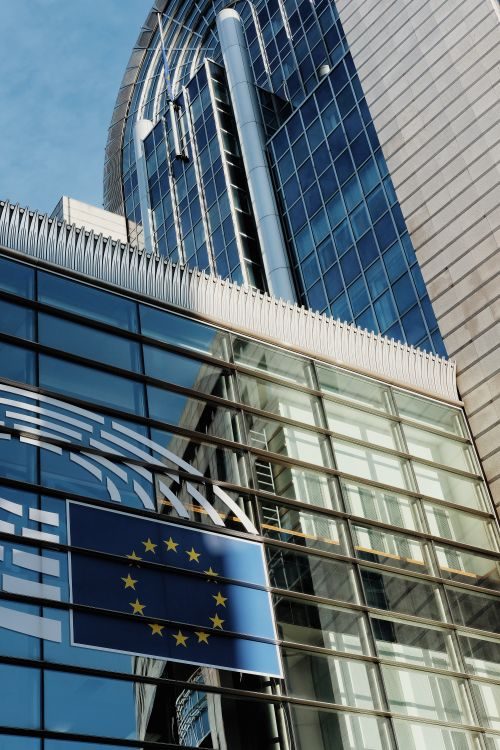 Modern glass office building with a European Union flag