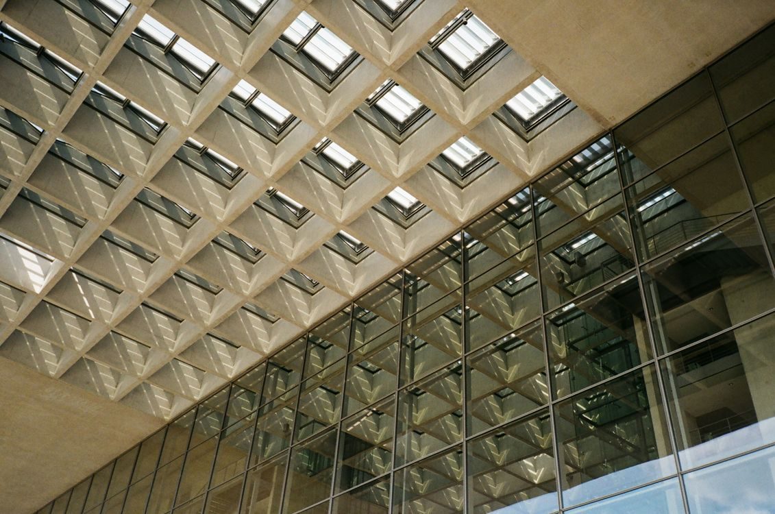 A geometric glass skylight ceiling in a modern office building