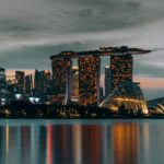 city skyline across body of water during night time